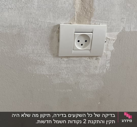 שקע חשמל בקיר עם טיח מתקלף
